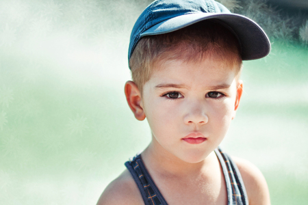 Cute little boy looking sadly straight at cameraの写真素材
