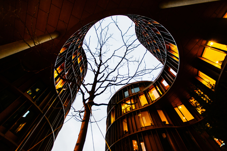 COPENHAGEN, DENMARK - MAY 01, 2018: A view towards the dark evening sky from public garden space of round Axel Towers, example of new Danish architecture in the centre of Copenhagen, comprising space for living, work, recreation, entertainmentのeditorial素材