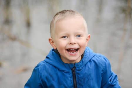 Happy cheerful smiling blond boy with blue eyes