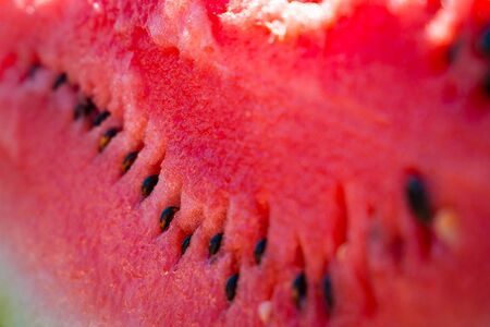Big juicy fresh red slice of ripe watermelon with black seeds. Fresh summer harvest. Eco-food. Close-up. Selective focus.の写真素材
