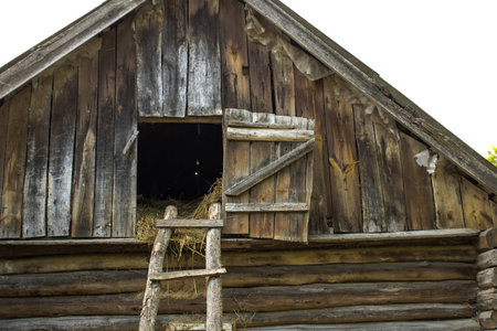 An old attic with a wooden staircase and hay in a village house