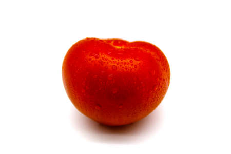 Red tomato in water drops close up isolated on a white backgroundの写真素材