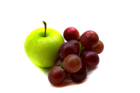 A bunch of grapes and a green Apple close up isolated on a white backgroundの写真素材