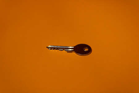 Iron chrome key close up on orange backgroundの写真素材