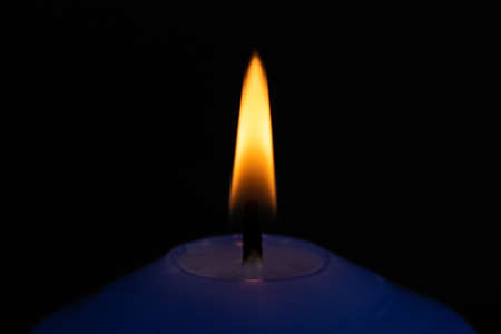 Candle flame close-up on a dark backgroundの写真素材
