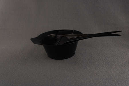 Black hair coloring kit: a container and two brushes on a gray backgroundの写真素材