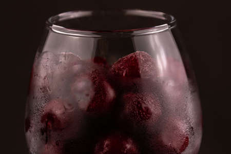 Frozen cherry in a glass close-up on a dark backgroundの写真素材