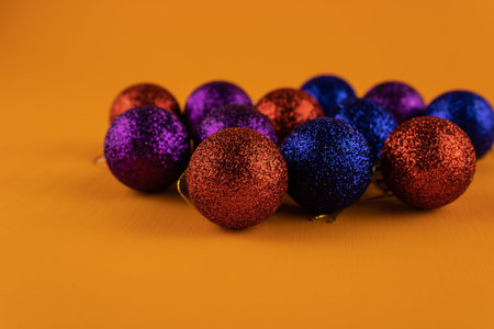 Colorful shiny Christmas balls on an orange backgroundの写真素材