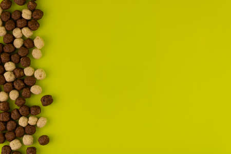 Chocolate and milk balls for breakfast on a light green background, top view, copy space.の写真素材
