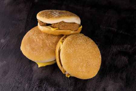 three mouthwatering delicious cheeseburger with chicken cutlet on wooden background close upの写真素材