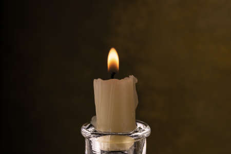 a burning candle in a glass candlestick close-upの写真素材