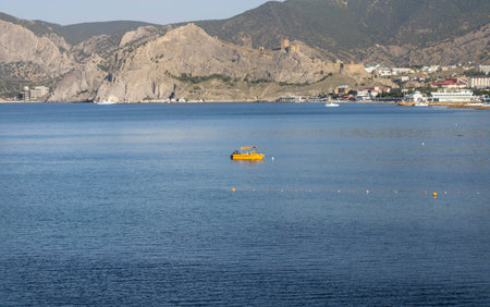 a sea bay at the foot of the mountains with residential buildings and a boat in the middle landscape