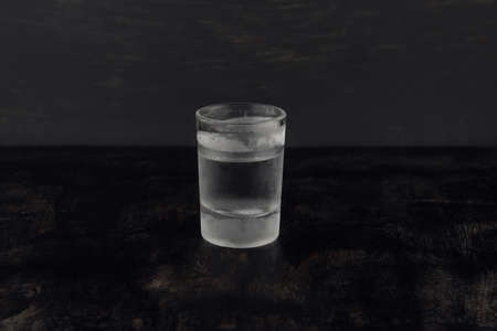 An icy glass of vodka on a dark wooden backgroundの写真素材