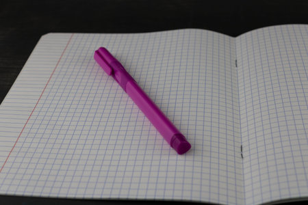 A textbook in a spread and a pink pen close-up.