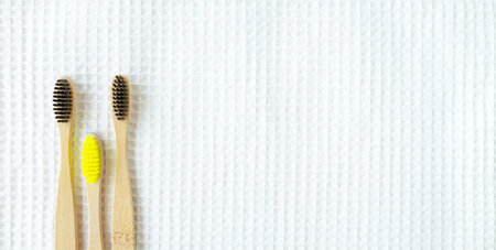 Eco natural bamboo toothbrushes on waffle towel background. Zero waste concept. Choice plastic free...