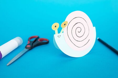 Step by step childrens cardboard crafts - colored swinging snail. Scissors, glue, paper sheets. Set for kids art. Children activity in kindergarten, school, at home. Step 8の写真素材