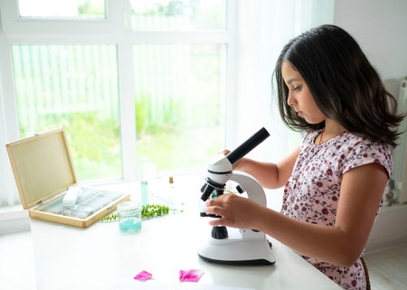 Pretty blonde little girl working with test tube and microscope. The kid learning science in the...