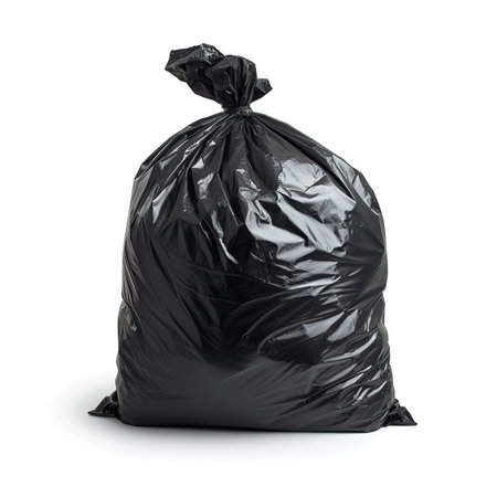 Black trash bag on a white background. The concept of waste disposal and cleanliness.の素材