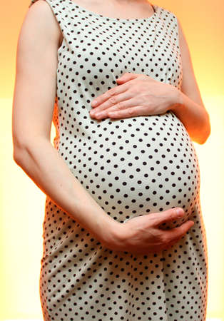 pregnant girl stands hugging her bellyの写真素材