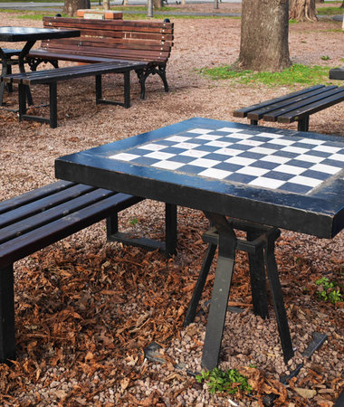 Outdoor chess table in city park with benches around. Public space for social interaction, leisure activities and community games in an urban environmentの写真素材