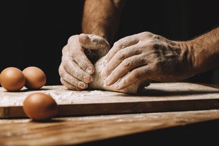 Men's hands make bread from raw dough.