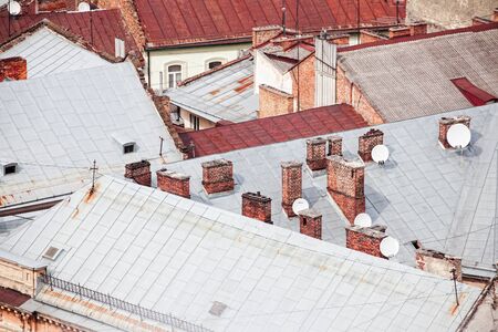 Top view on the roofs of old brick houses with chimneys.の写真素材