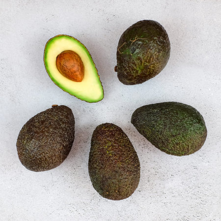Fresh avocado on grey background. Vegetarian food concept. Top view.