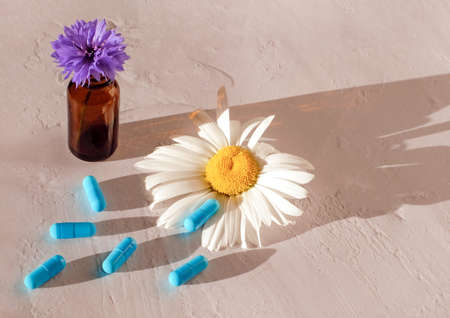 Natural pills and bottle with flower. Composition on textured background as alternative herb medicine, close upの写真素材