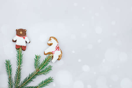 Creative christmas cookies and fir branches on grey bokeh background with copy spaceの写真素材