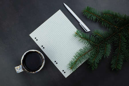 Paper for notes and pen on grey dark backround, coffee mug, spruce branchesの写真素材
