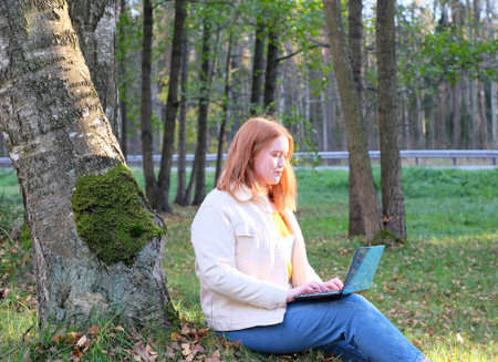 Freelancer young woman plus size working with laptop, sunlight effect on face. Outdoor, mobile...