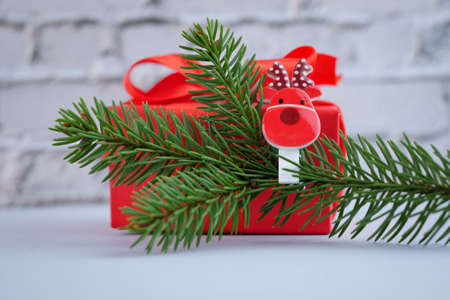 Christmas composition with fir branches decorated with the symbol of 2021 bull cow and red gift box on brick backgroundの写真素材