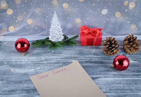 Letter to Santa Claus and christmas decoration on wooden table near window