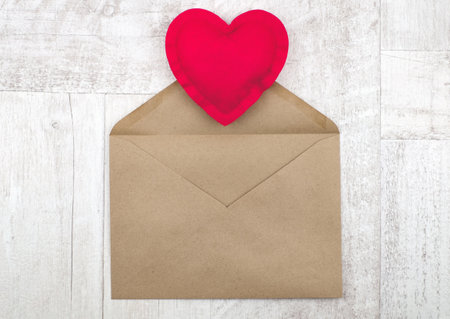 Red heart and envelope for holidays on wooden background, message with love idea, top viewの写真素材