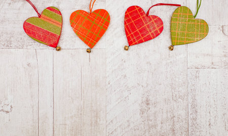 Three wooden hearts at the top on wooden background. Copy spaceの写真素材