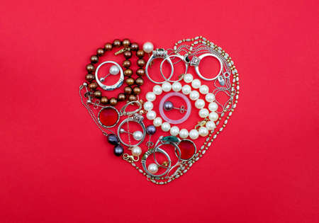 A lot of jewelry made in heart shape on red backgroundの写真素材