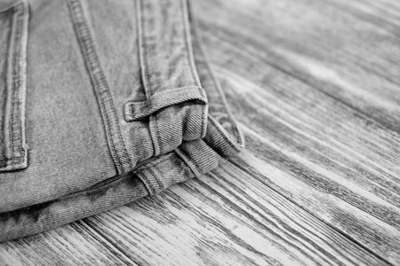 Black and white, jeans on wooden background, fashion trend, close-up, selective focusの写真素材