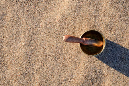 Himalayan tibetian singing bowl on sand, top view. Copy spaceの写真素材