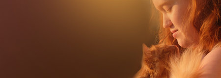 Redhead young woman with a fluffy red cat with sunlight