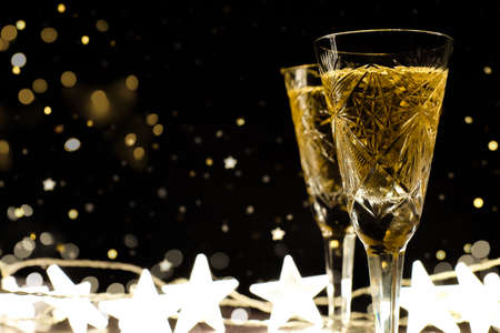 Two glasses of champagne on black background with New Year decor, copy spaceの写真素材