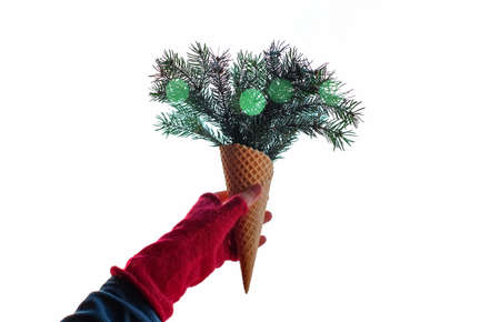 Waffle cone with branches and green bokeh in the hand in glove on white backgroundの写真素材