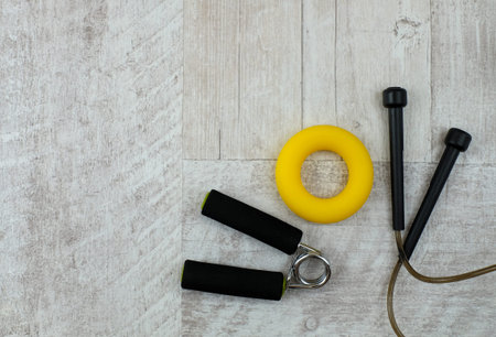 Fitness accessories on gray wooden background. Healthy lifestyle concept. Top view with copy space