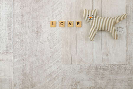 Toy cat and word love on wooden background, copy space, top viewの写真素材