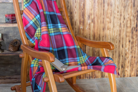 wooden rocking chair with a plaid in a large cageの写真素材