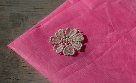 flower-shaped applique on pink needlework textiles, decorative elementsの写真素材