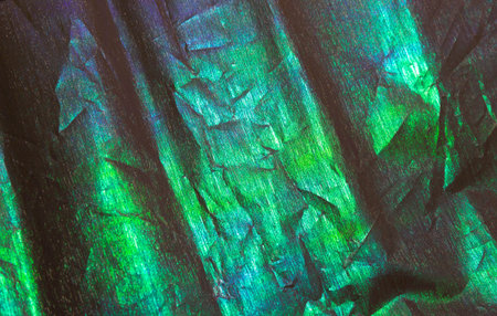 the base for the decoration of gifts and packaging is green with blue shades and a golden coating, uneven color, with creasesの写真素材