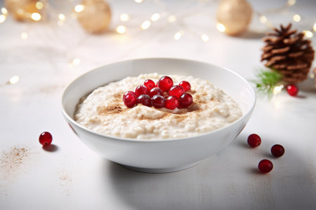 Oatmeal porridge with cranberries in a white bowl on a white wooden backgroundの素材