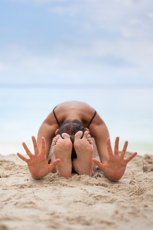 woman meditating in a yoga pose on beachの写真素材
