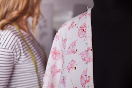 Portrait of female dressmaker adjusting clothes. 