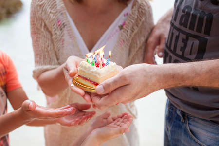 Dad lights the cake on the cake. Family birthday party.の写真素材